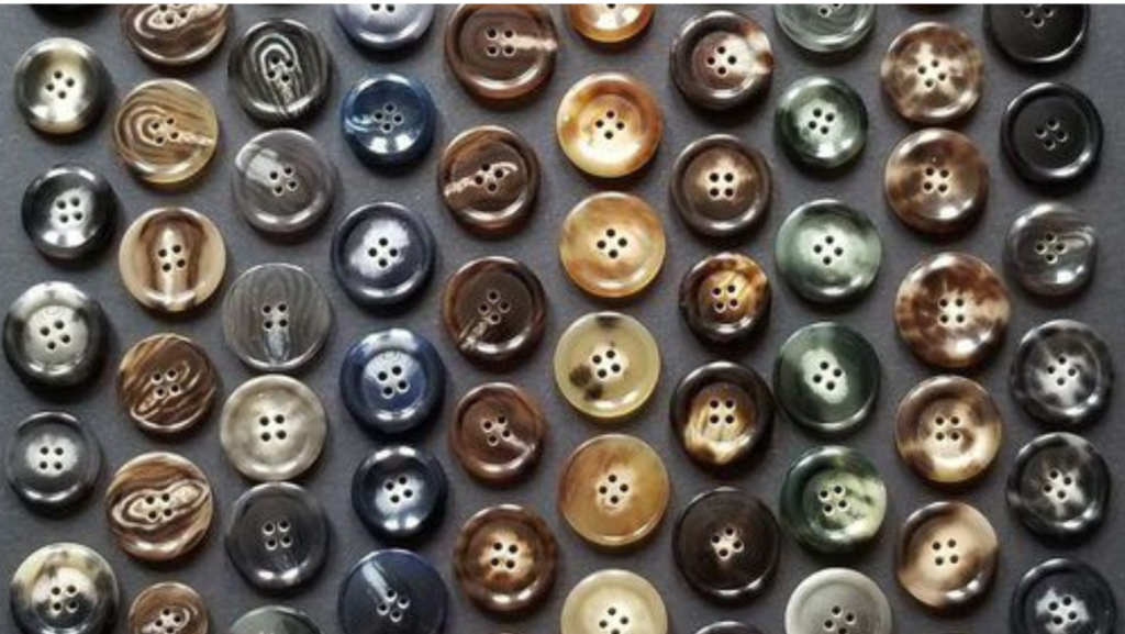 Landscape of Horn buttons of different shades and sizes, aesthetically placed on a dark surface